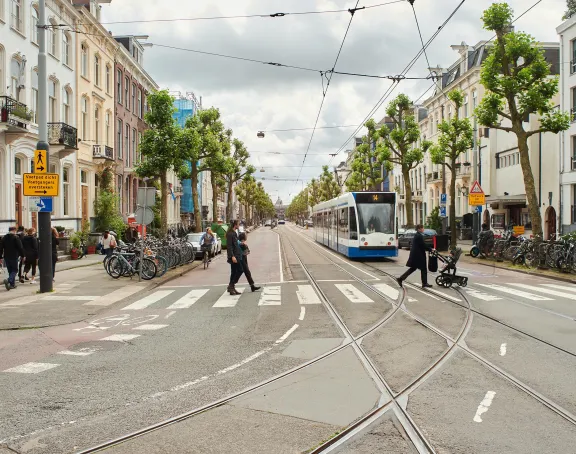 Street in Amsterdam with a zebra crossing and a tram
