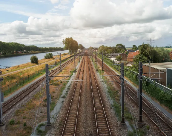 Train tracks with a river on the left