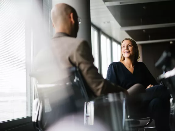 A female and male Stibbe lawyer having a chat while seated in a meeting room at Stibbe in Brussels